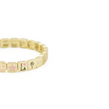 Gold bracelet with various beads on a white background