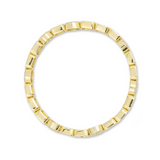 Gold ring with a geometric design on a white background
