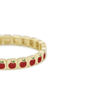 Gold bracelet with red apple charms on a white background