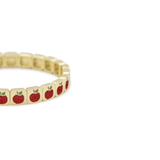 Gold bracelet with red apple charms on a white background