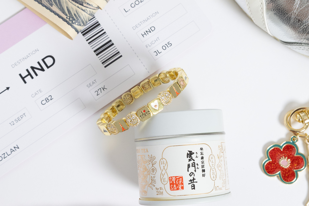 Gold bracelet on background with cherry blossom key chain