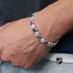 Silver-tone charm bracelet with blue round team-logo discs on a small chain band