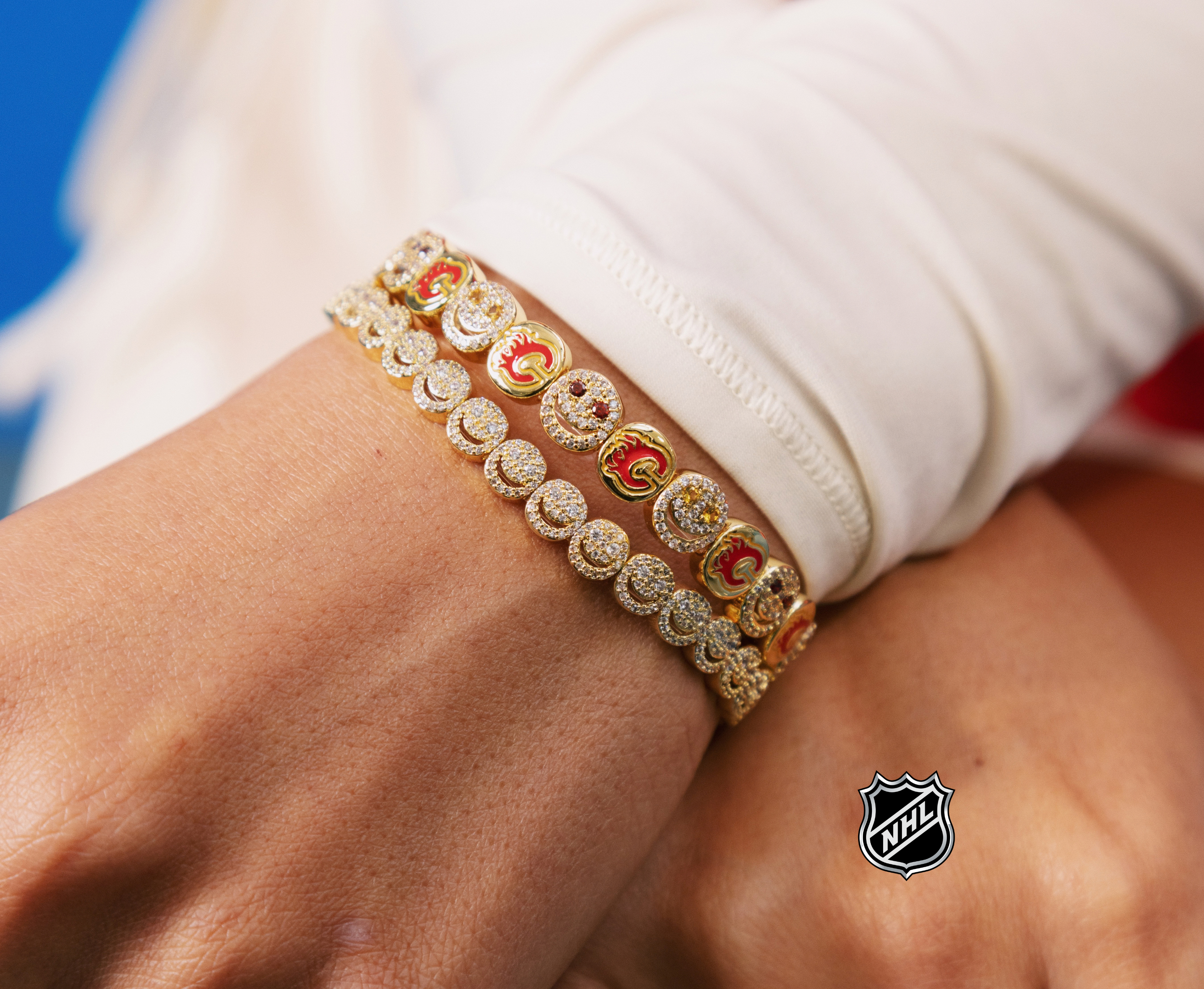 Gold-tone NHL charm bracelet with multicolor crest details and round stone accents