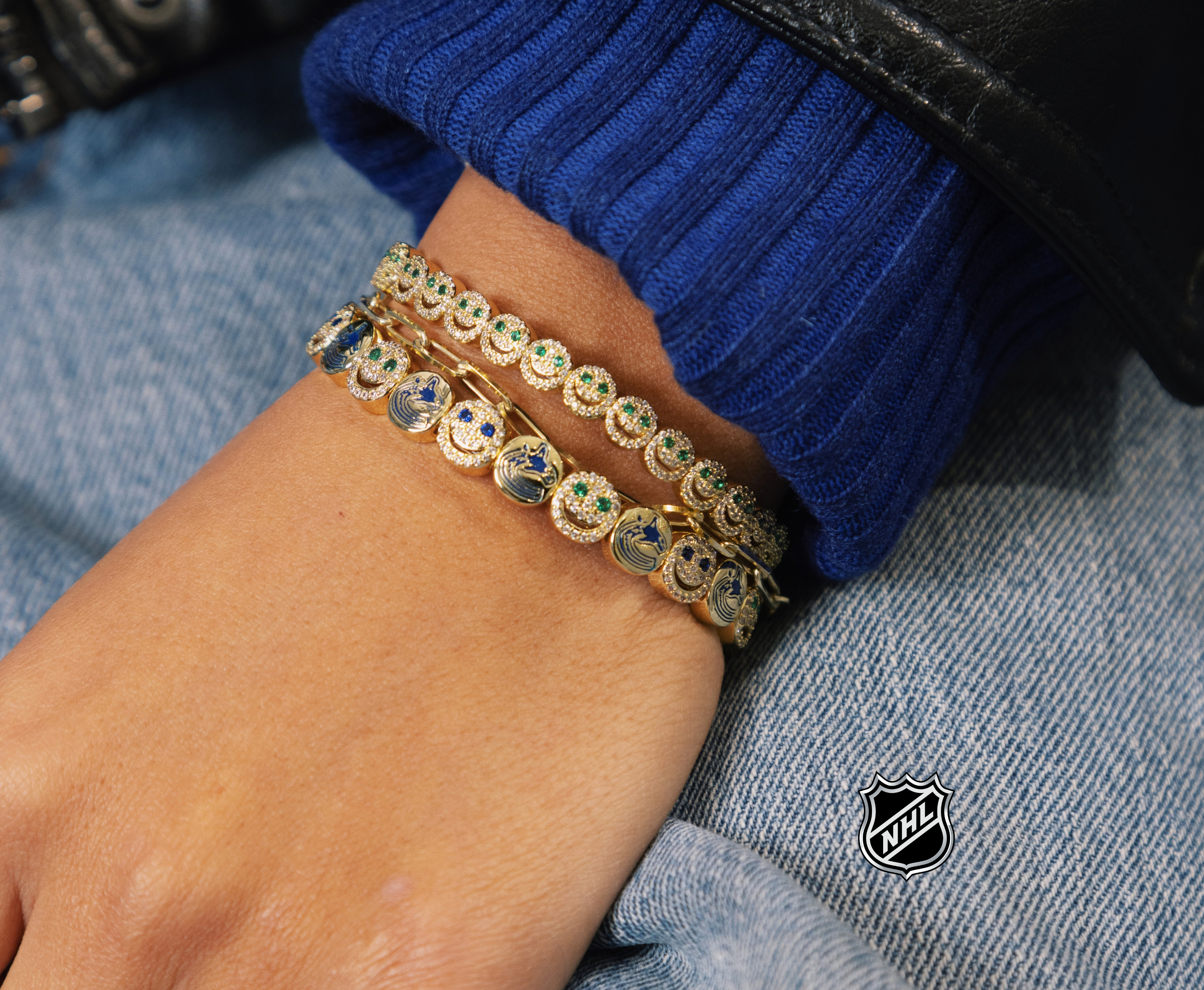 Gold-tone NHL charm bracelet with round team-logo discs on a stacked chain