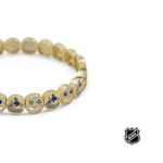Gold NHL® bracelet close-up along the edge with team-logo charm beads