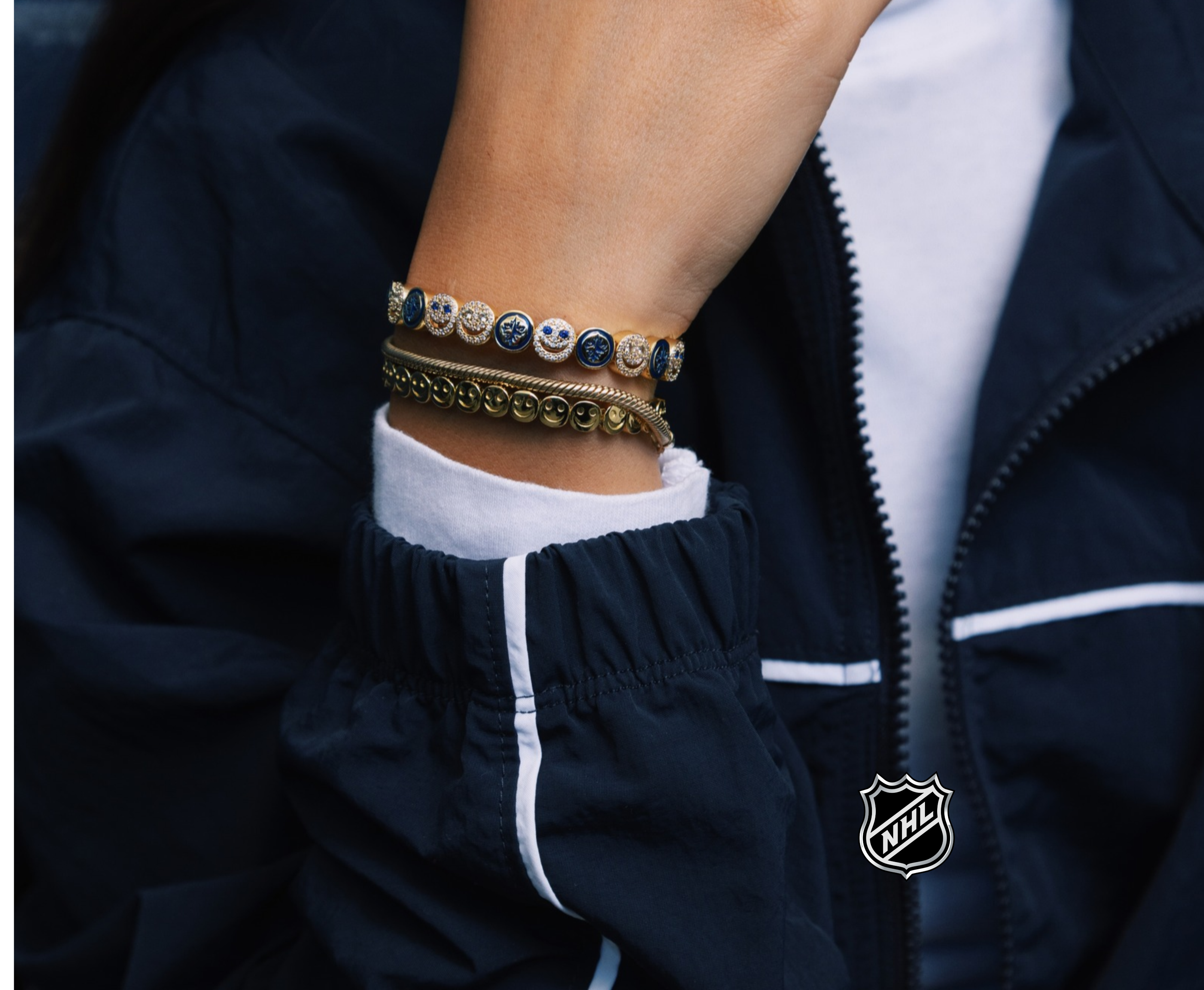 Silver-tone charm bracelet with small round team-logo discs on layered chain