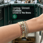 Close-up of a wrist with multiple bracelets in an urban setting
